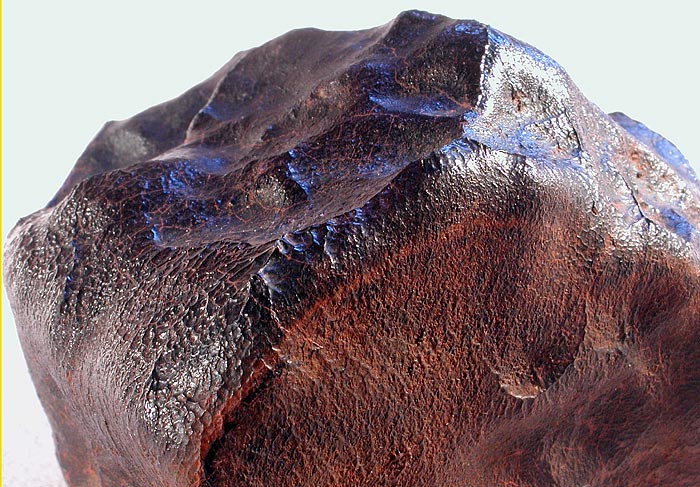 Millbilillie - eukryt. Cudowna skorupa obtopieniowa tego eukrytu ma lekko czerwonawe zabarwienie. Pomimo bardzo małej zawartości frakcji magnetycznej (magnes nie reaguje) - skorupa z czasem rdzewieje, co pomaga w znalezieniu tego typu meteorytów. Źródło zdjęcia:   http://www.meteoritehunter.com/